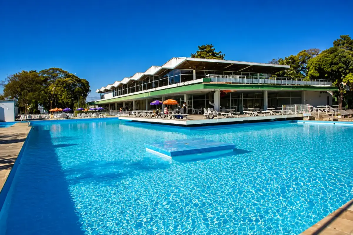 Piscina grande do clube parceiro com a sede ao fundo
